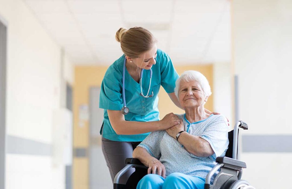 Older adult choosing clothing with a caregiver in a bright assisted living apartment.
