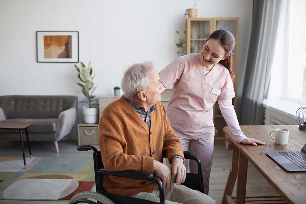 Older adult reviews health care documents with a family member at a kitchen table.